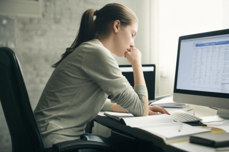 Mujer concentrada frente a una computadora, dificultad para concentrarse.