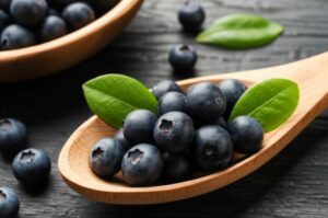 Aronia chokeberries frescos en una cuchara de madera