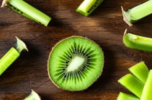 Imagen de un kiwi en rodajas sobre una tabla de madera, mostrando su pulpa verde vibrante y semillas negras.