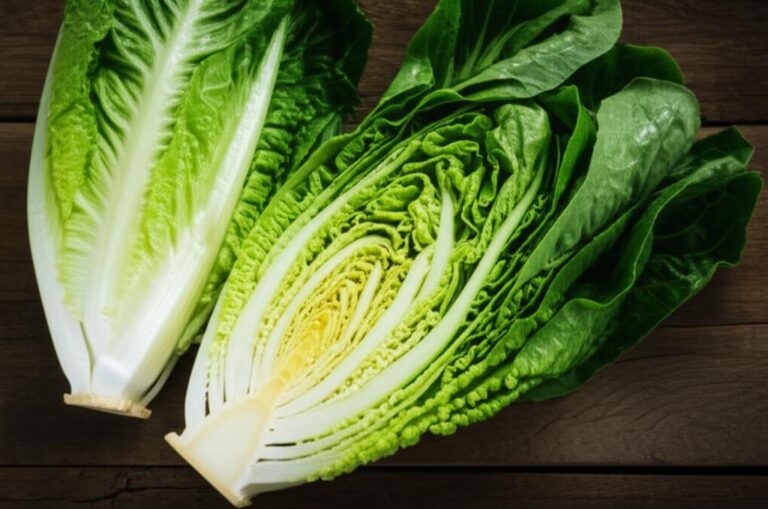 Lechuga romana fresca, una entera y otra cortada longitudinalmente, sobre superficie de madera, destacando sus hojas verdes y amarillentas para información nutricional.