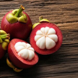 Imagen de mangostanes enteros y cortados mostrando la pulpa blanca, sobre una superficie de madera, para información nutricional.