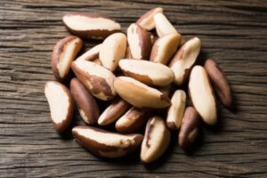 Grupo de nueces de Brasil sobre una superficie de madera, enfoque en sus propiedades nutricionales.