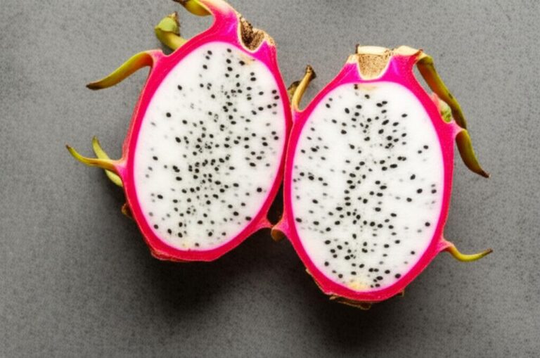 Dos mitades de pitahaya mostrando la pulpa blanca con semillas negras sobre fondo gris